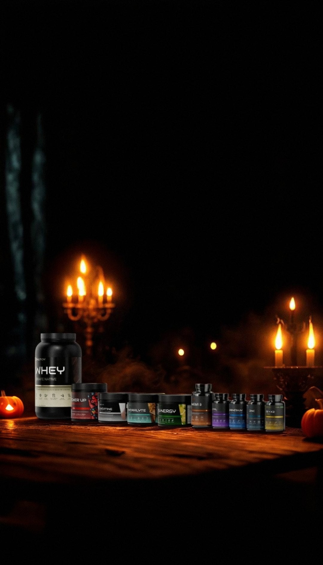 La gamme Coalition sur une table sombre, éclairée par des bougies, avec des citrouilles d’Halloween